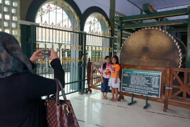 Pengunjung berfoto dengan bedug pendowo di Masjid Darul Muttaqin Purworejo, Jawa Tengah