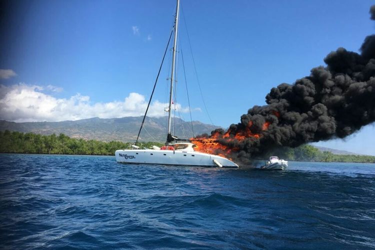 Kapal yacht Next Chapte milik warga Australia yang terbakar di Perairan Maumere, Kabupaten Sikka, Nusa Tenggara Timur (NTT), Jumat (14/7/2017)