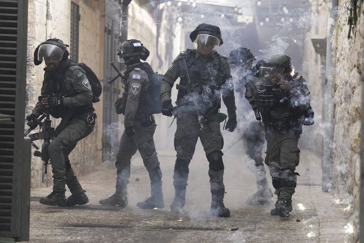 Warga Palestina menembakkan kembang api ke arah polisi Israel di Kota Tua Yerusalem, Minggu, 17 April 2022.