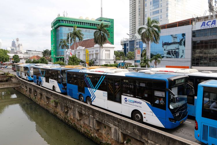 Maskot Manusia Covid membawa poster bertulisakan data penderita Covid-19 terlihat di Halte Transjakarta Harmoni, Kamis (16/7/2020). Maskot Manusia Covid bertujuan mengingatkan penumpang Transjakarta untuk disiplin mematuhi prosedur kesehatan selama masa PSBB Transisi Tahap II berlangsung.