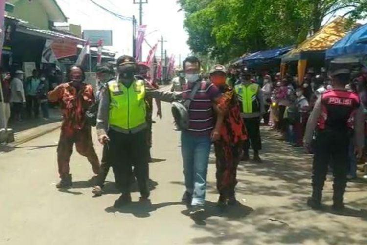 Polisi mengamankan seorang warga yang diduga akan membentangkan poster saat rombongan Presiden Jokowi melintas di Jalan Ketapang, Cilacap, Jawa Tengah, Kamis (23/9/2021).