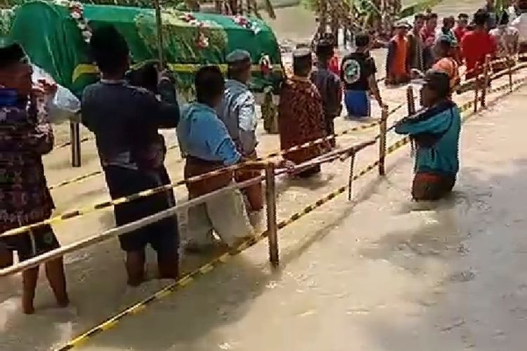 Video amatir berdurasi satu menit yang mendokumentasikan rombongan warga Kecamatan Klambu, Kabupaten Grobogan, Jawa Tengah berjalan kaki mengangkut jenazah, menerjang derasnya banjir viral di perpesanan Whatsapp.