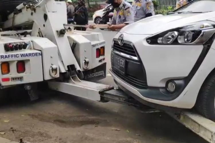 Sebanyak tujuh mobil diderek petugas saat penertiban parkir liar di Jalan Matraman Raya, Matraman, Jakarta Timur, Senin (6/12/2021).