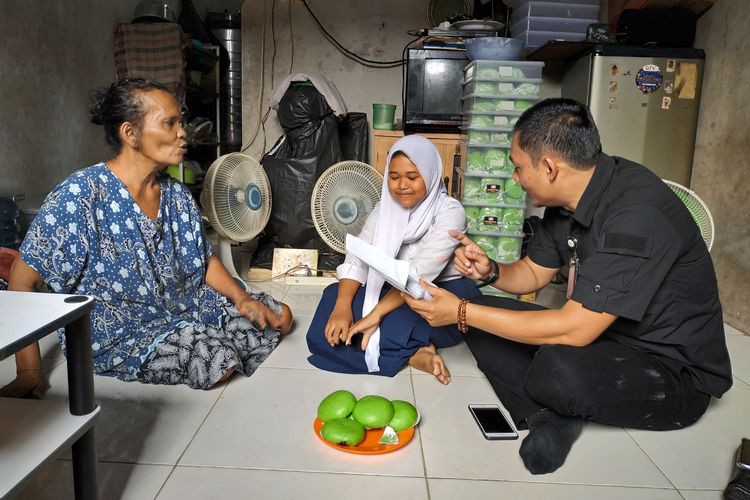 Staff kepresidenan yang diutus oleh Joko Widodo memberikan bantuan kepada Dewi Febriyanti (13) yang merupakan siswi SMP penjual bakpao di Pom Bensin daerah Ciledug pada (25/7/2019) 
