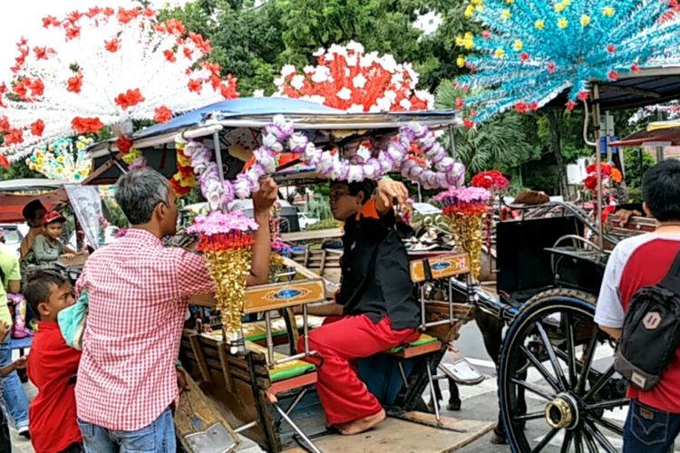 Delman hias diparkir di pinggir jalan Lapangan IRTI, Monas, Jakarta Pusat, Selasa (26/12/2017).