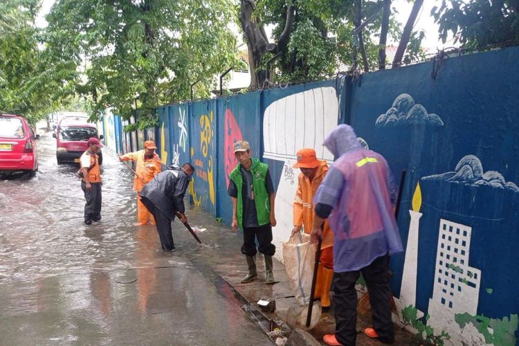Petugas PPSU dan SDA Jakarta Utara mempercepat aliran air yang merendam Jalan Mangga, Koja pada Jumat (24/2/2023). Ketinggian air yang merendam kawasan ini mencapai 20 sentimeter. 