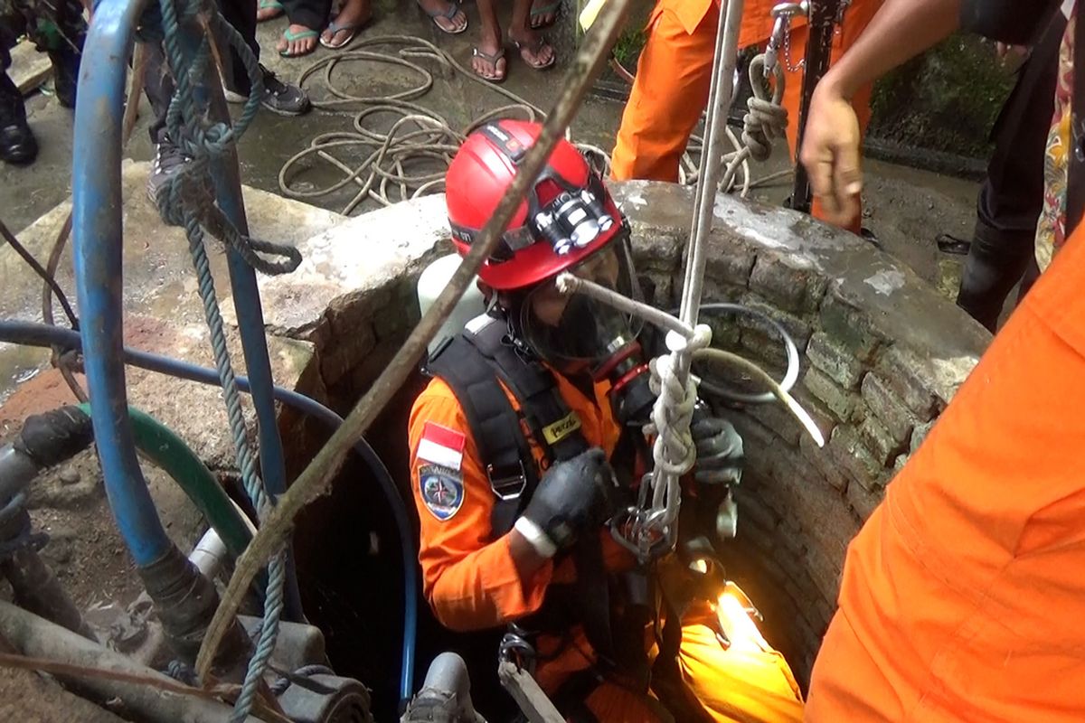 Anggota Basarnas Pos SAR Trenggalek, berupaya melaklukan evakuasi korban di dasar sumur, Kamis (24/02/2022).
