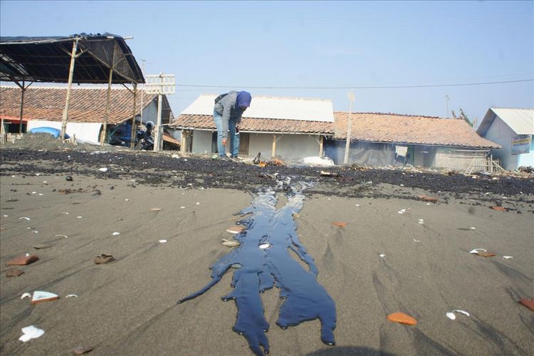 Api dinyalakan di tumpahan minyak di pantai Desa Cemarajaya, Kecamatan Cibuaya, Kabupaten Karawang, Senin (22/7/2019).