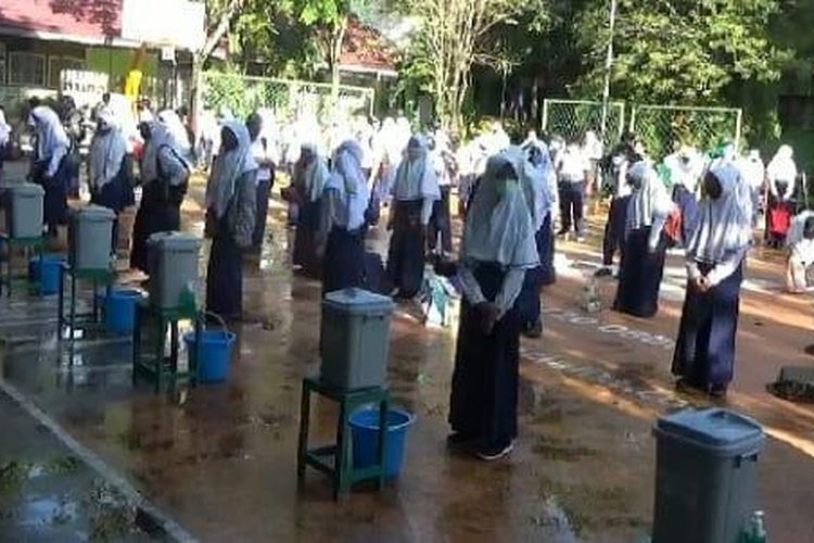 Belajar tatap muka di Kota Banjarmasin dimulai, Senin (16/11/2020). Sebelum masuk ke kelas siswa dikumpulkan dilapangan untuk mencuci tangan dan dilakukan pemeriksaan suhu tubuh.