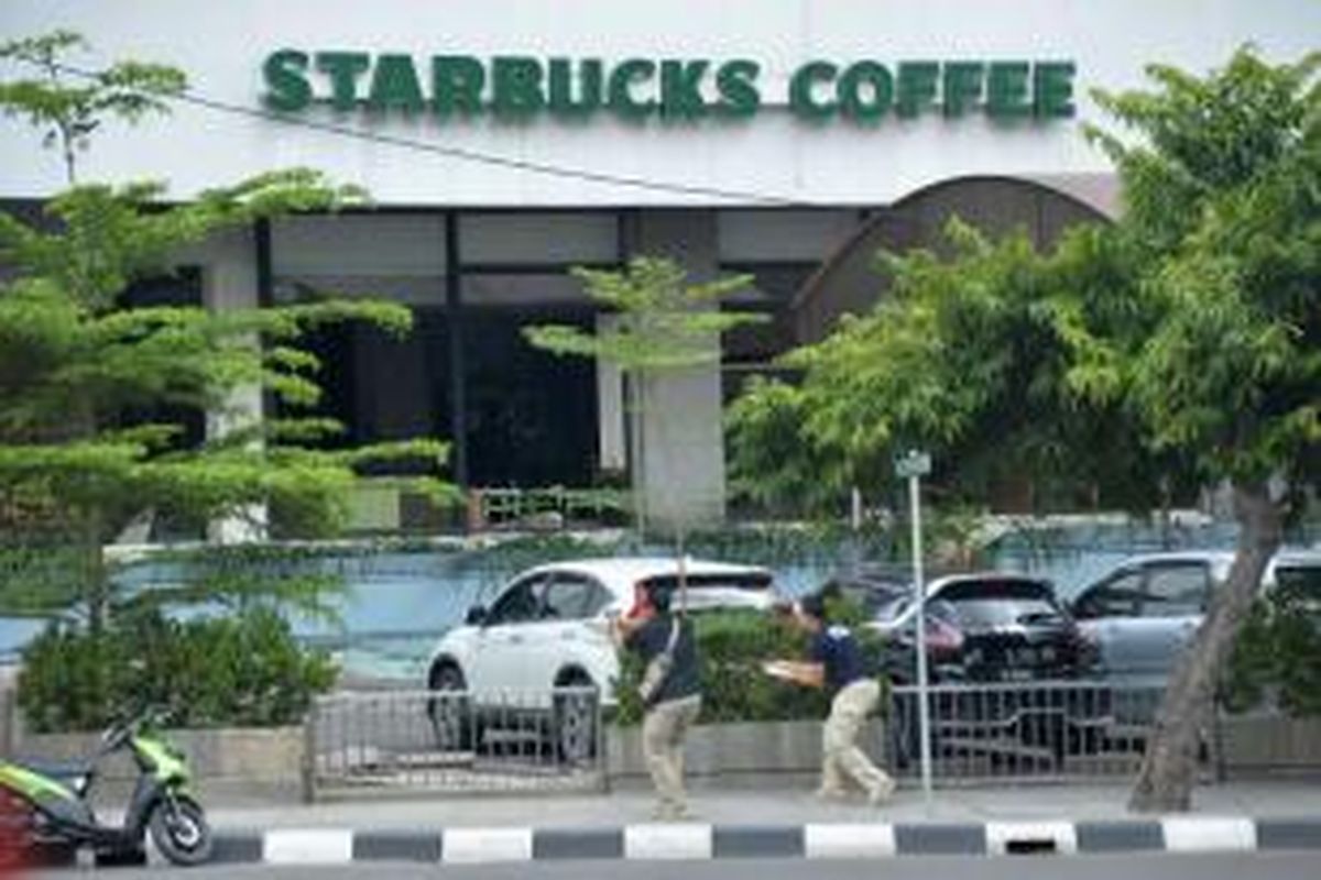 Polisi berpakaian sipil mengarahkan pistol ke arah terduga pelaku di luar sebuah kafe setelah ledakan menghantam kawasan Jalan MH Thamrin, Jakarta Pusat, 14 Januari 2016. Serangkaian ledakan menewaskan sejumlah orang, terjadi baku tembak antara polisi dan beberapa orang yang diduga pelaku.