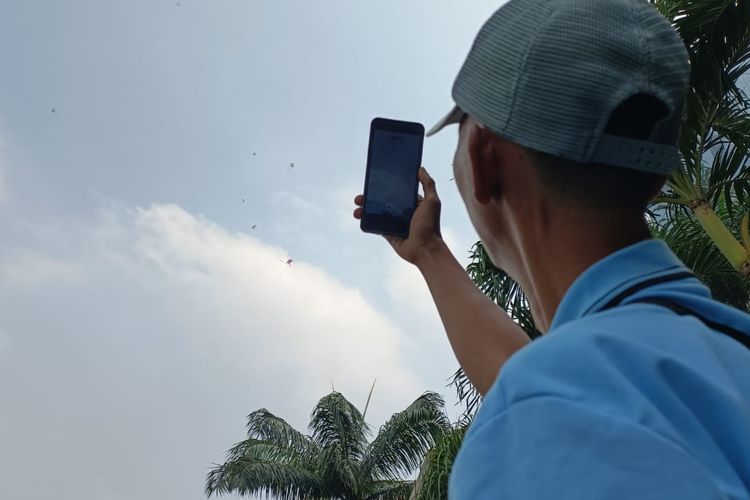 Seorang warga yang tampak antusias melihat atraksi terjun payung yang dilakukan oleh prajurit TNI dalam HUT TNI ke-78 di Jalan MH Thamrin, Menteng, Jakarta Pusat, Kamis (5/10/2023).