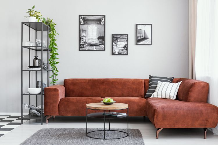 Ilustrasi ruang tamu dengan sofa cokelat. 