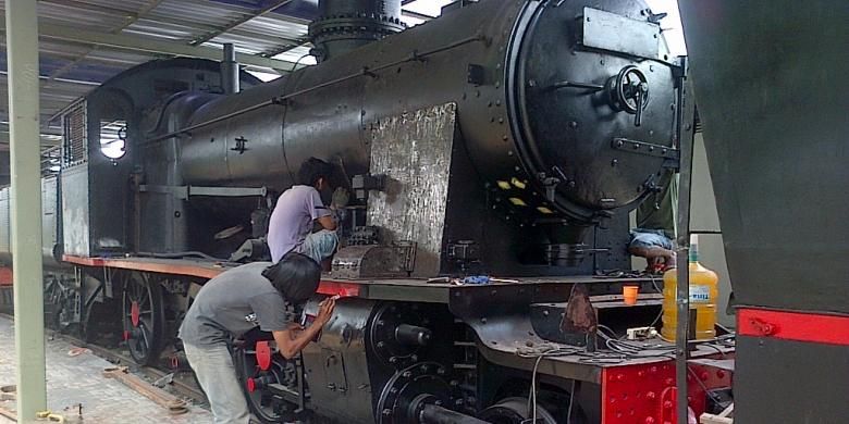 seorang pekerja tengah mengecat ulang salah satu lokomotif uap koleksi Museum Ambarawa, Rabu (28/1/2015) siang.
