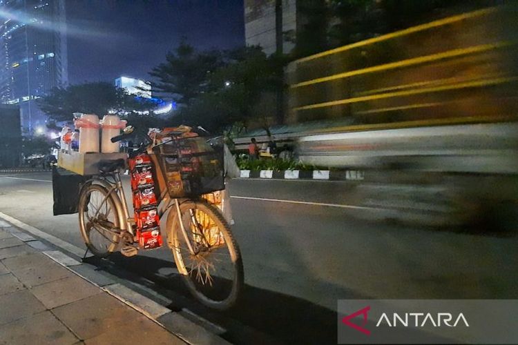 Pedagang kopi dengan menggunakan sepeda di kawasan Sudriman, Jakarta pusat, Senin (4/7/2022). (ANTARA/Chairul Rohman)