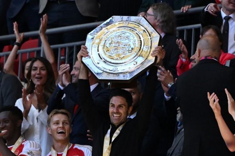 Manajer Arsenal, Mikel Arteta, mengangkat trofi Community Shield usai timnya mengalahkan Manchester City lewat adu penalti dalam laga yang digelar di Stadion Wembley, London, pada Minggu (6/8/2023).