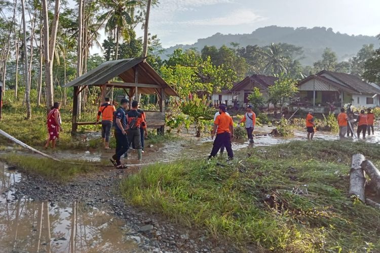 Petugas BPBD dan relawan bencana membantu warga Desa Kandangan, Kecamatan Pesanggaran, Kabupaten Banyuwangi, Jawa Timur, membersihkan rumah dari bekas banjir, Selasa (22/3/2022).