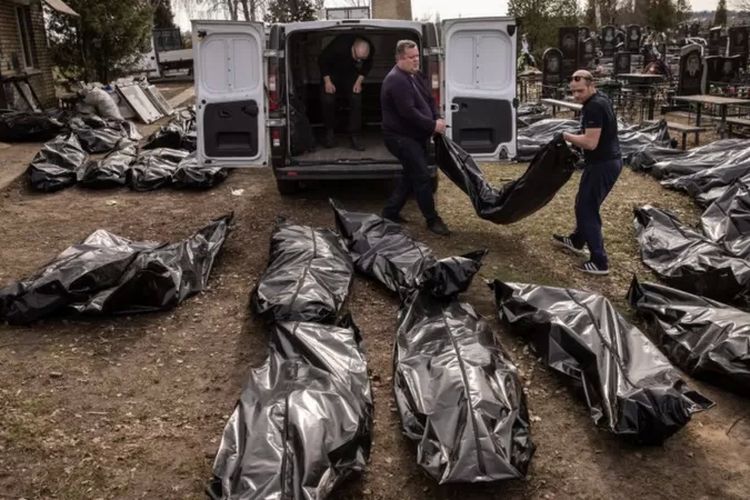 Petugas memindahkan mayat-mayat yang ditemukan bergelimpangan di jalanan dan rumah warga untuk dikuburkan di tempat pemakaman Kota Bucha, Ukraina, 7 April 2022.

