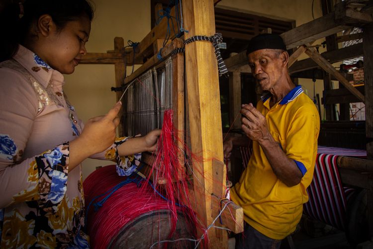 Klaten, Indonesia - October 10, 2020, craft workers from father and daughter are putting strings on threads for traditional LURIK garment crafts in Pedan, Klaten, Indonesia