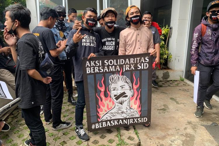 Beberapa fans SID yang biasa disebut Outsider terlihat berkumpul di sekitar gedung Pengadilan Negeri (PN) Jakarta Pusat, Selasa (22/2/2022). Mereka membawa beberapa poster, menuntut Jerinx bebas hingga tangkap Adam Deni.