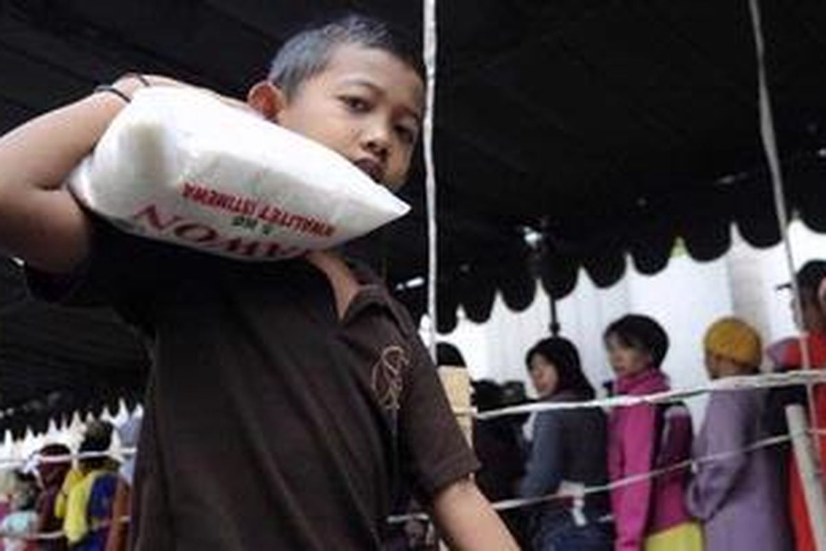 Warga miskin membawa karung beras pada saat pemberian zakat di Kantor Chalidana Group di Jalan Raya Wiyung, Kota Surabaya, Sabtu (11/8/2012). Jelang Hari Raya Idul Fitri banyak instansi maupun perseorangan  yang mengeluarkan  zakat untuk warga miskin.   