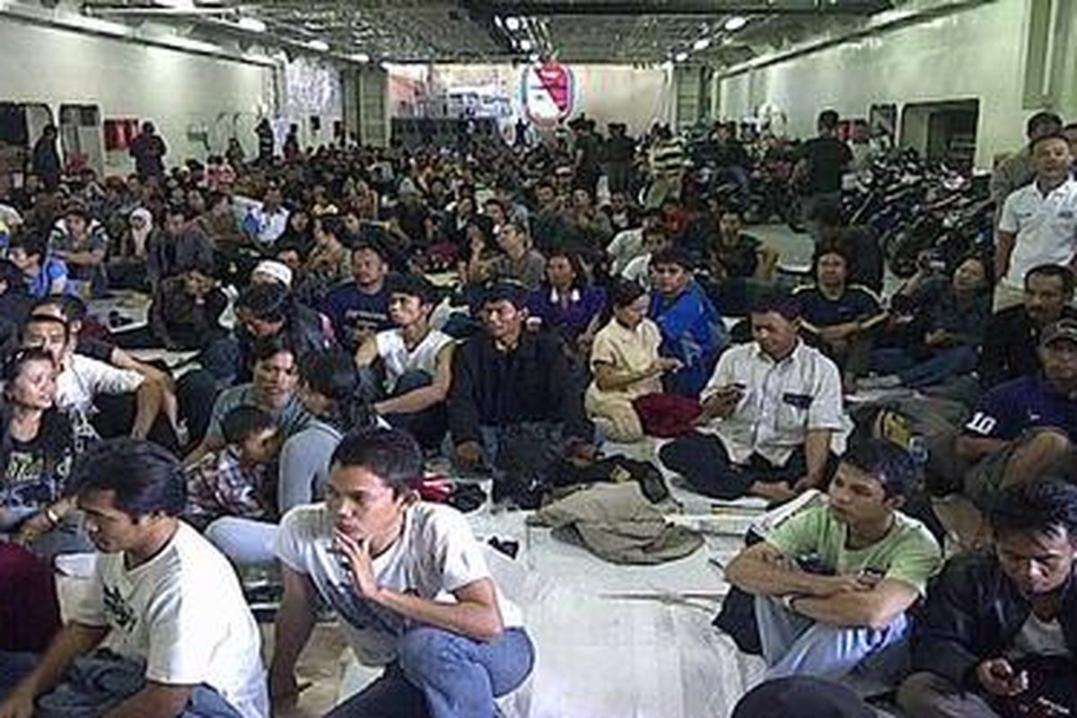 Ratusan peserta mudik gratis dengan kapal perang KRI Banjarmasin 592 saat berada di tank deck dalam perjalanan dari pelabuhan Tanjung Priok, Jakarta, menuju Tanjung Emas, Semarang, Jawa Tengah. Kegiatan mudik gratis ini diikuti 690 orang dan 298 sepeda motor.