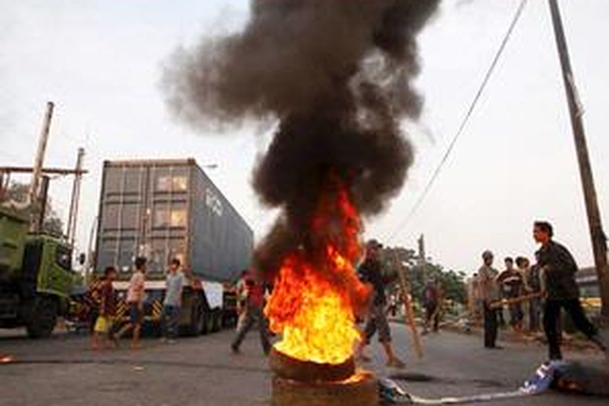 Warga perumahan liar di Taman BMW, Jakarta Utara, membakar ban dan menyandera truk untuk memblokir Jalan Laksamana RE. Martadinata, saat ribuan anggota Satuan Polisi Pamong Praja hendak membongkar rumah-rumah mereka, Minggu (24/8).