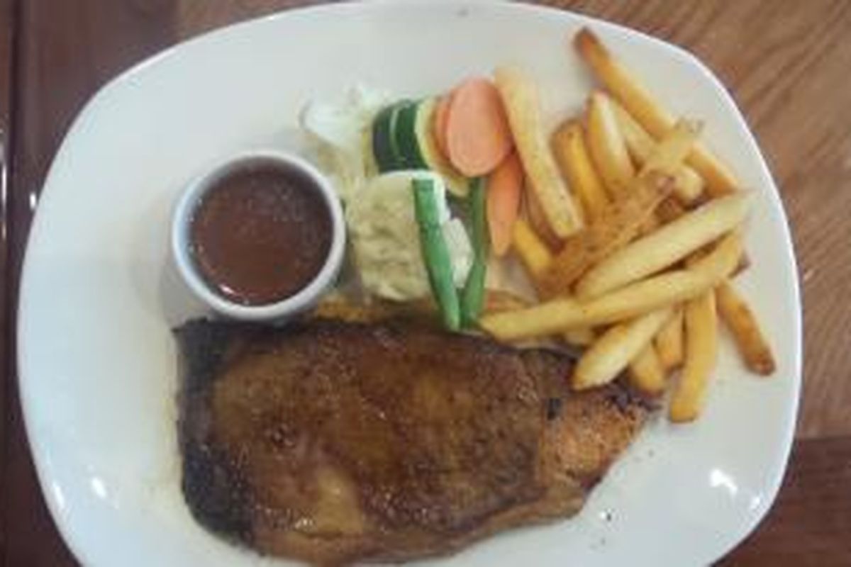 Hidangan steak di Outback Steakhouse dengan tingkat kematangan medium well, disajikan bersama sayuran dan kentang goreng.