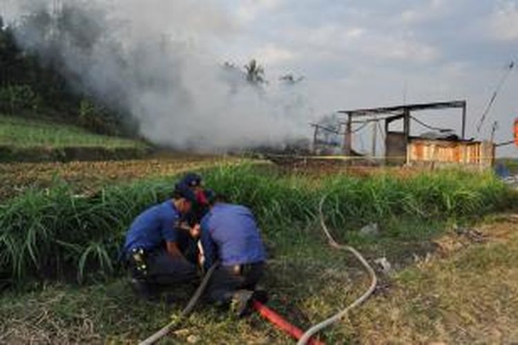 Regu pemadam kebakaran dari BPPD Kabupaten Semarang berupaya memadamkan api yang melalap gudang kain perca di Ungaran, Senin (22/9/2014) siang.