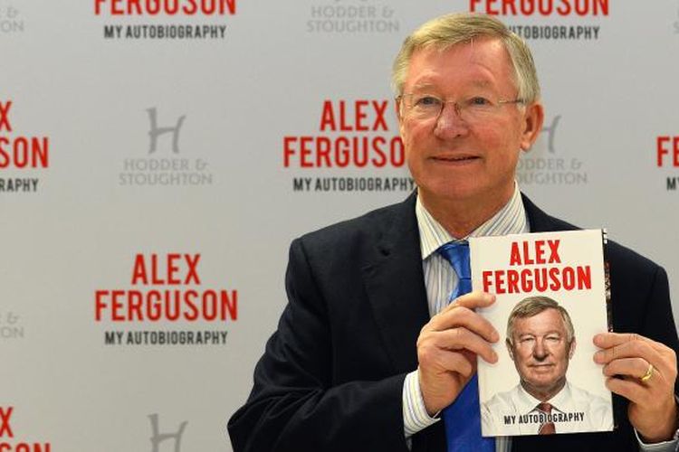 Alex Ferguson menunjukkan buku otobiografinya sebelum acara penandatanganan, di sebuah supermarket, di Manchester, 24 Oktober 2013. 