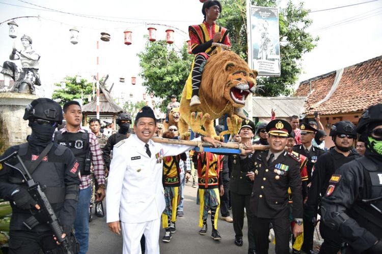 Bupati Purwakarta Dedi Mulyadi memikul Sisingaan bersama Kapolres Purwakarta AKBP Hanny saat memperingati HUT Bhayangkara di Alun-alun daerah setempat, Senin (10/7/2017). 