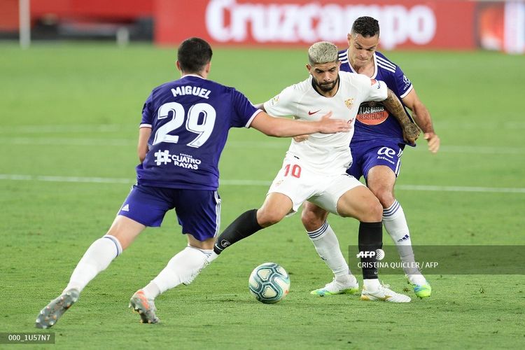 Pemain depan Valladolid Spanyol Miguel (kiri) dan bek Valladolid dari Italia Federico Barba (kanan) menantang pemain tengah Sevilla asal Argentina Ever Banega selama pertandingan sepak bola Liga Spanyol antara Sevilla dan Real Valladolid di stadion Ramon Sanchez Pizjuan di Sevilla pada 26 Juni 2020.