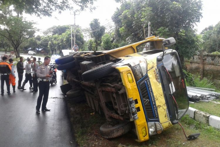 Sebuah truk pengangkut baja ringan terguling di Jalan Raya Tegar Beriman, Cibinong, Kabupaten Bogor, Selasa (16/1/2018).