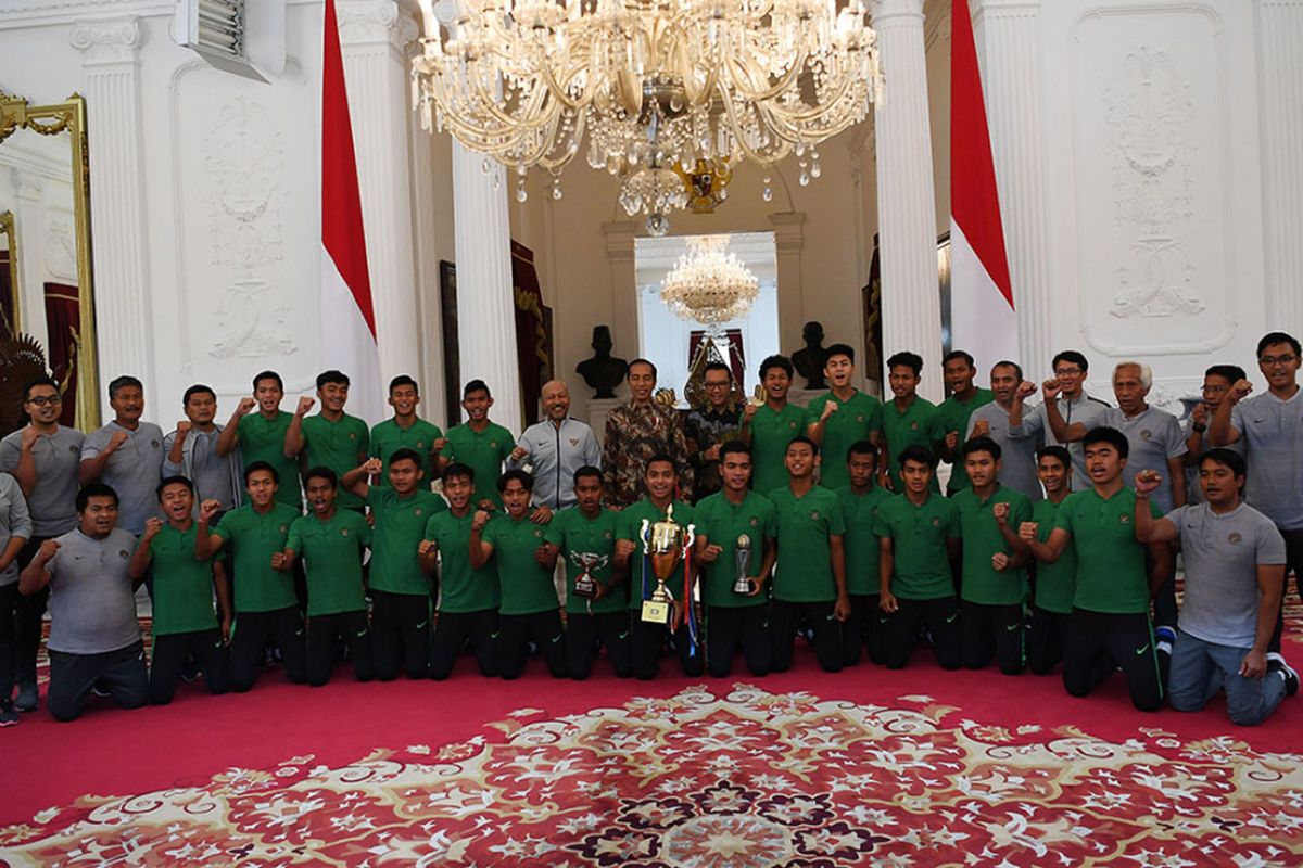 Presiden Joko WIdodo (tengah) didampingi Menpora Imam Nahrawi (sembilan kanan) serta pelatih Fachry Husaini (sembilan kiri) berfoto dengan pemain Timnas U-16 serta tim ofisial di Istana Merdeka, Jakarta, Kamis (4/10/2018). Presiden mengapresiasi prestasi Timnas U-16 yang menjadi juara Piala AFF U-16 2018 serta mampu menembus perempat final Piala Asia.