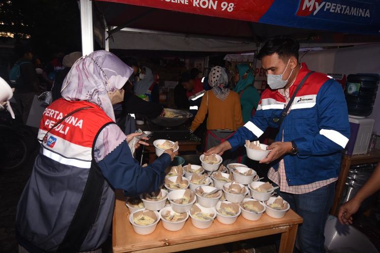 Relawan Pertamina Peduli menyiapkan bubur untuk para pengungsi di dapur umum Pertamina Peduli di RPTRA Rasele, Rawa Badak, Koja, Jakarta, Sabtu (4/3/2023).