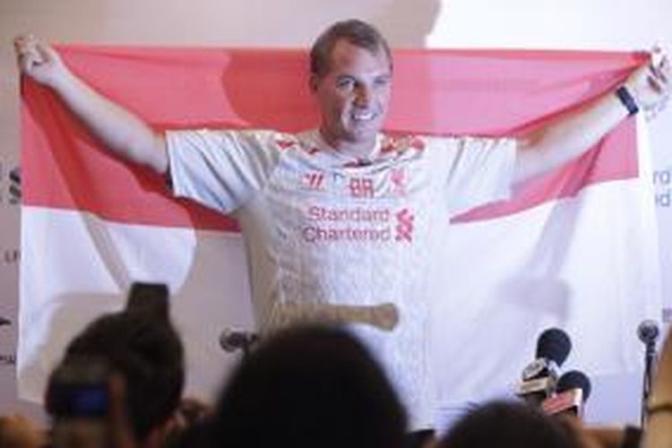 Manager klub Liverpool, Brendan Rodgers, mengangkat bendera Indonesia seusai memberikan keterangan pers di Hotel Mulia, Senayan, Jakarta, Kamis (18/7/2013).