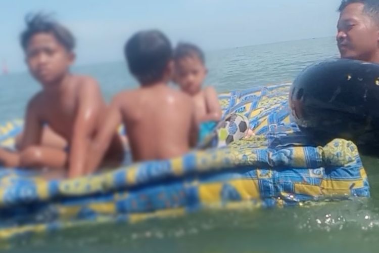 Tiga bocah menaiki kasur bekas dan mengapung di tengah laut di kawasan OW PAI Kota Tegal, Minggu (20/3/2022) (Dok. Lanal Tegal)