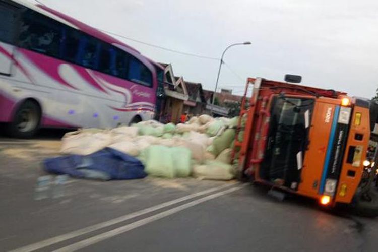 Truk bermuatan pakan ternak yang terguling di Jalan Raya Duduk Sampeyan, Gresik, Senin (23/1/2017).