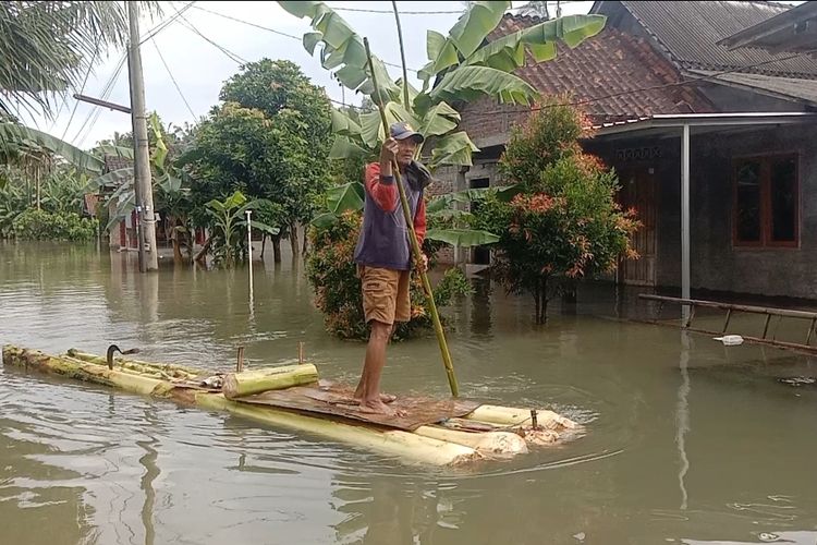 KEBANJIRAN: Warga Desa Wironatan, Purworejo beraktivitas menggunakan perahu sederhana yang dibuat dari pohon pisang, Selasa (30/1/2024)