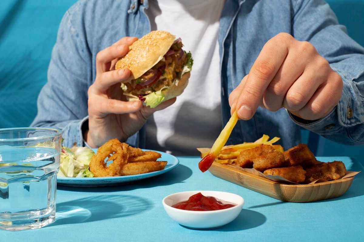Ilustrasi makan makanan cepat saji, salah satu faktor yang memercepat penurunan fungsi kognitif.