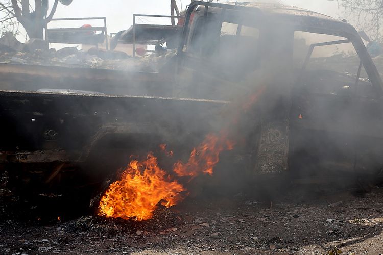 Gambar yang diambil pada 24 Oktober 2018 memperlihatkan sebuah kendaraan yang terbakar setelahi dihantam rudal dari jet tempur koalisi pimpinan Arab Saudi. Koalisi menggelar serangan udara ke Hodeida, Yaman, untuk merebut kota tersebut dari kelompok Houthi.