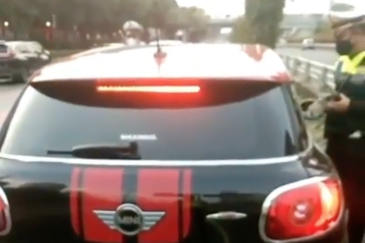 Beredar video di media sosial pengemudi mobil Mini Cooper yang ditilang oleh petugas di Exit Tol Semanggi, Jalan Gatot Subroto, Jakarta Selatan, Minggu (16/5/2021).

