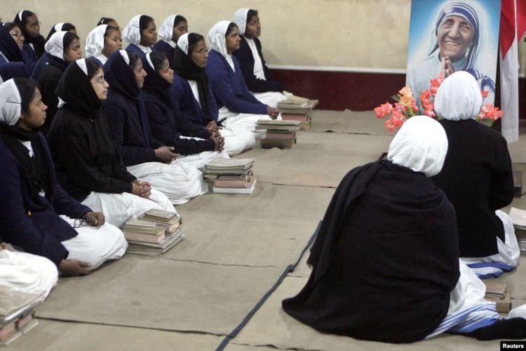 Foto ilustrasi. Para biarawati India mengelilingi potret Bunda Theresa di Kolkata. India memblokir aliran dana asing ke Missionaries of Charity.