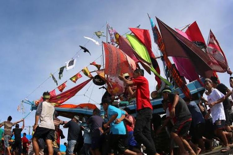 Sejumlah warga menghiasi perahu saat perayaan Maulid Penutup (Maudu Lompoa) di Cikoang, Takalar, Sulsel, Selasa (20/1/2015). Maudu Lompoa dilaksanakan sebagai penutup perayaan Maulid Nabi Muhammad SAW yang diadakan setiap tahun dengan menghiasi perahu para nelayan menggunakan telur, selendang, sarung, dan pakaian. 