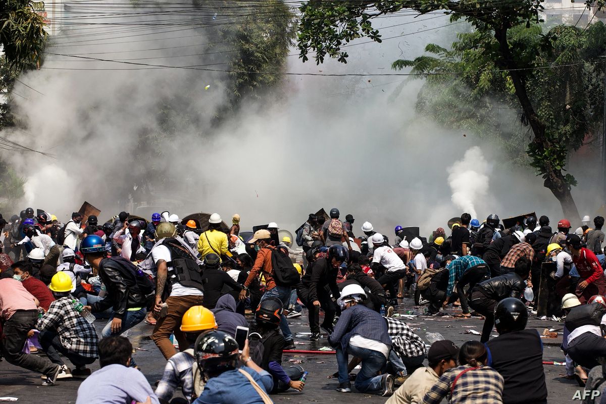 Protesters react after police fired tear gas during a demonstration against the military coup in Mandalay, Myanmar, March 3, 2021