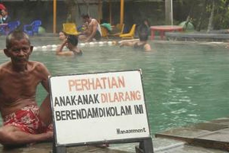 Seorang lansia sedang menyegarkan diri sejenak di tepi kolam pemandian, Sari Ater, Subang, Jawa Barat.