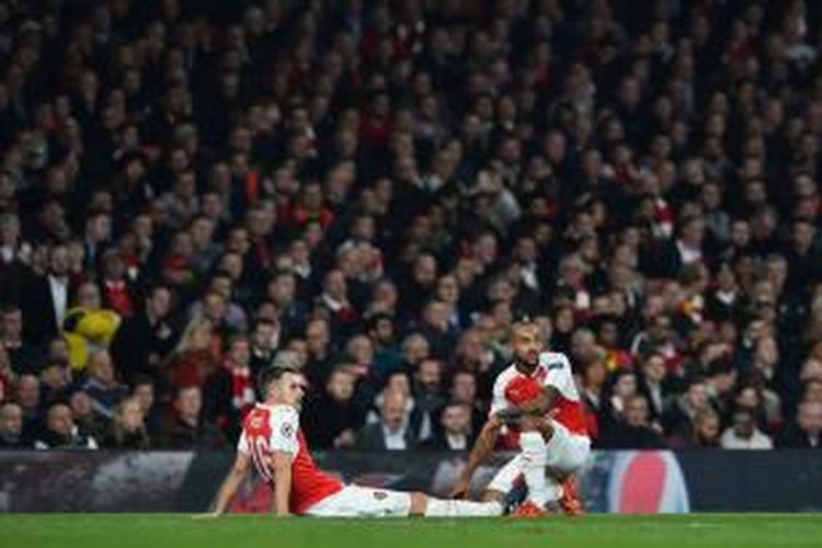 Gelandang Arsenal, Aaron Ramsey (kiri), mengalami cedera otot paha saat Arsenal menghadapi Bayern Muenchen pada lanjutan Liga Champions di Stadion Emirates, Selasa (20/10/2015).