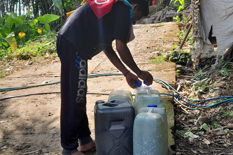 Warga mengambil air di sumber mata air di Dusun Gebang, Desa Semambung, Kecamatan Jatibanteng, Kabupaten Situbondo.