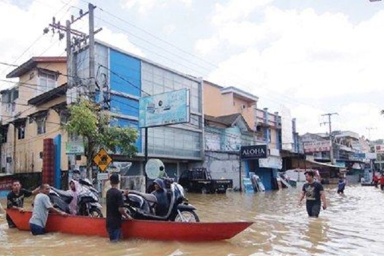 Kendaraan bermotor milik warga diangkut menggunakan perahu akibat banjir yang menutup Jalan Ahmad Yani, Samarinda, Senin (10/6/2019).