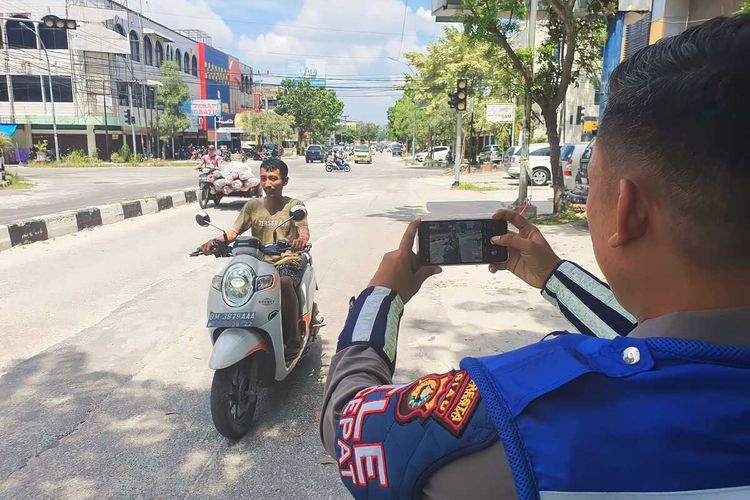 Petugas Satlantas Polresta Pekanbaru melakukan uji coba penerapan tilang ETLE mobile untuk menindak pelanggar lalu lintas di Kota Pekanbaru, Riau, Kamis (25/5/2023).