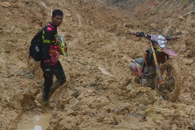 Salah satu pengendara kendaraan roda dua yang terjebak kumbangan lumpur di Jalan Trans Papua Barat, yang menghubungan Kabupaten Manokwari Selatan dan Kabupaten Teluk Bintuni, Sabtu (8/6/2019).